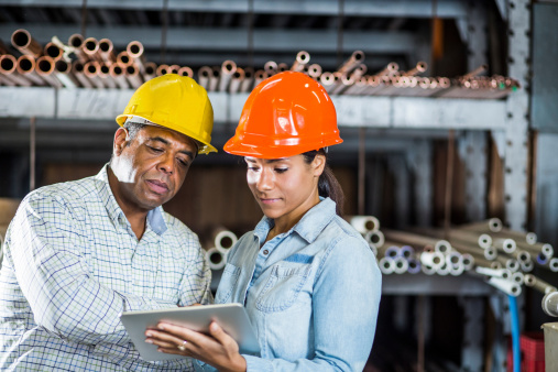 Man and woman in warehouse looking at digital tablet