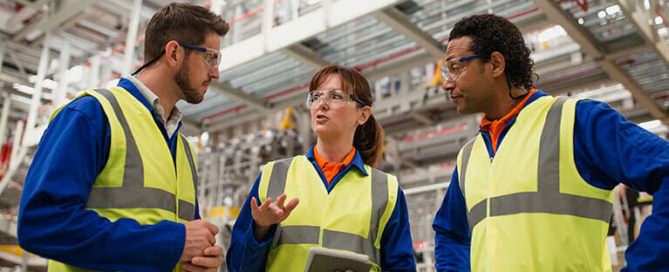 workers discuss preventive maintenance in a factory