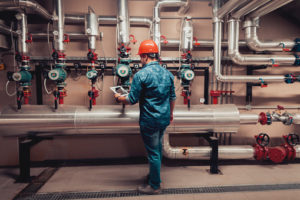 Um trabalhador de manutenção industrial revê dados de equipamento num comprimido