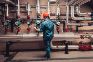 An industrial maintenace worker reviews equipment data on a tablet