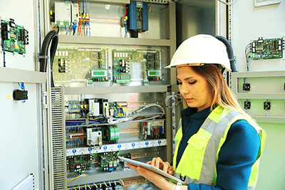 Mujer que utiliza el software de órdenes de trabajo eMaint CMMS en una instalación de mantenimiento.
