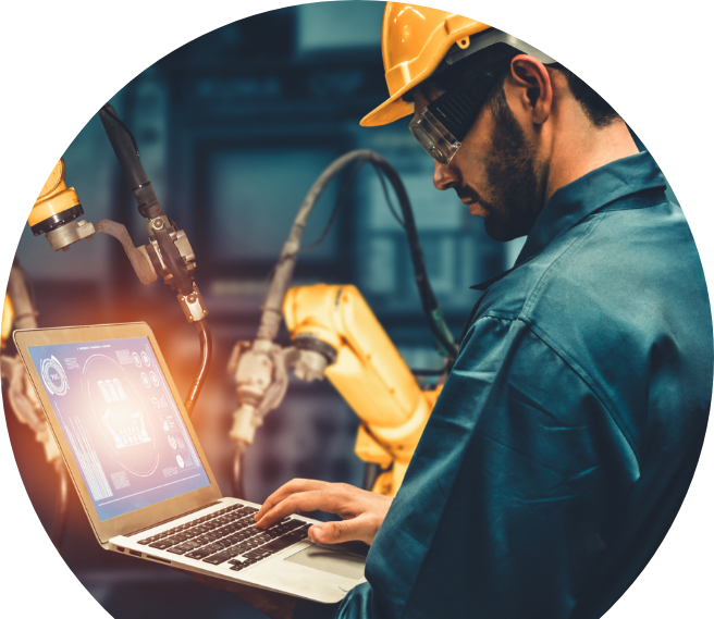 Maintenance worker wearing yellow hard hat and goggles while standing and using a laptop