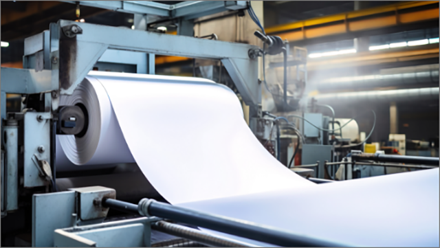Industrial-sized roll of white paper in a packaging plant